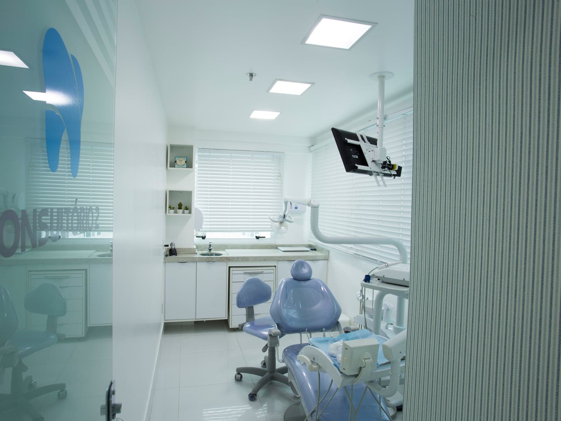 Consultório Orto Implan com cadeira azul e identidade visual