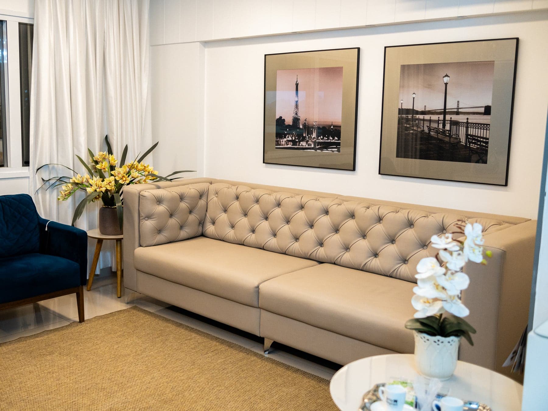 Lounge Orto Implan com sofá tufado e quadros